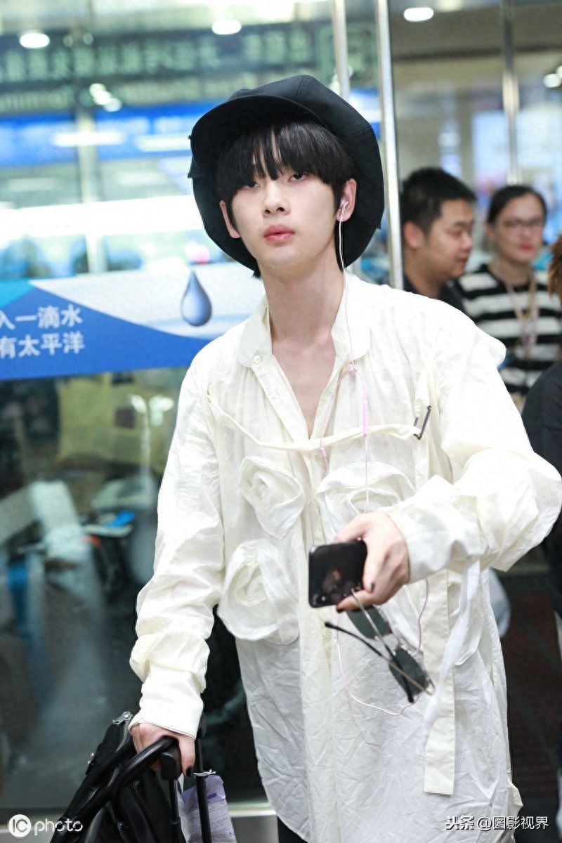 男歌手周震南现身机场，穿白衣服戴贝雷帽，涂黑色指甲油个性十足