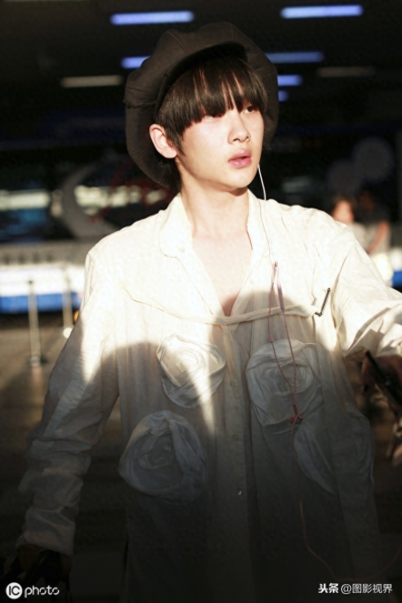 男歌手周震南现身机场，穿白衣服戴贝雷帽，涂黑色指甲油个性十足