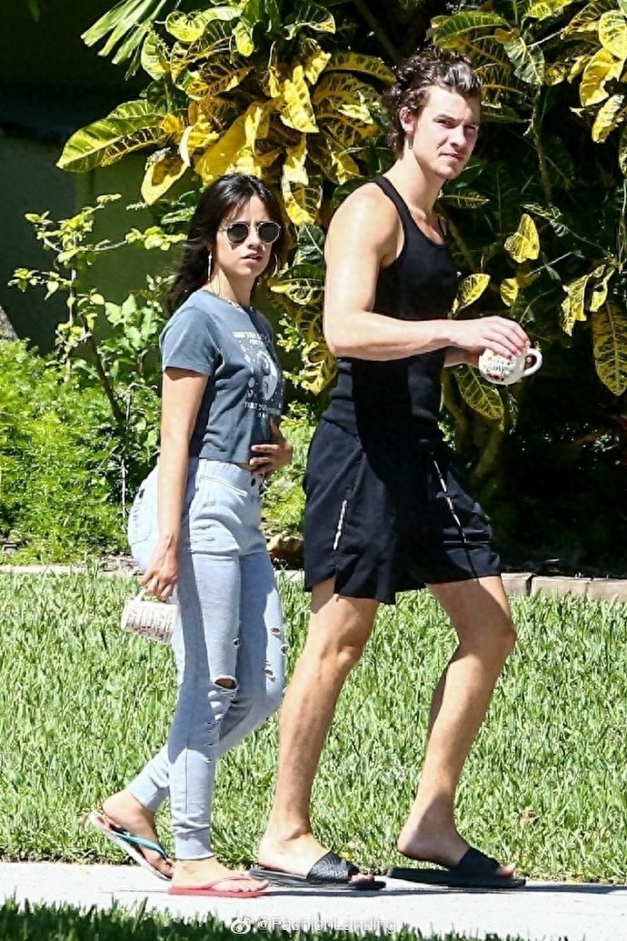 萌德和女友卡妹街头散步,手牵手秀恩爱,手里依旧拿着马克杯